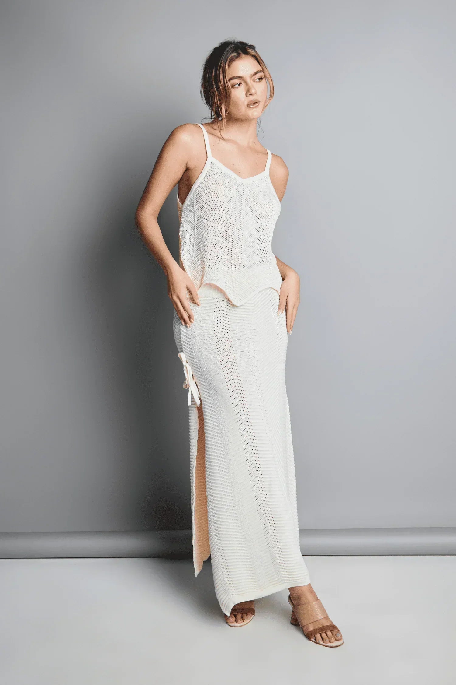 Mujer con conjunto de top y falda larga en tejido de punto blanco, moda femenina elegante.